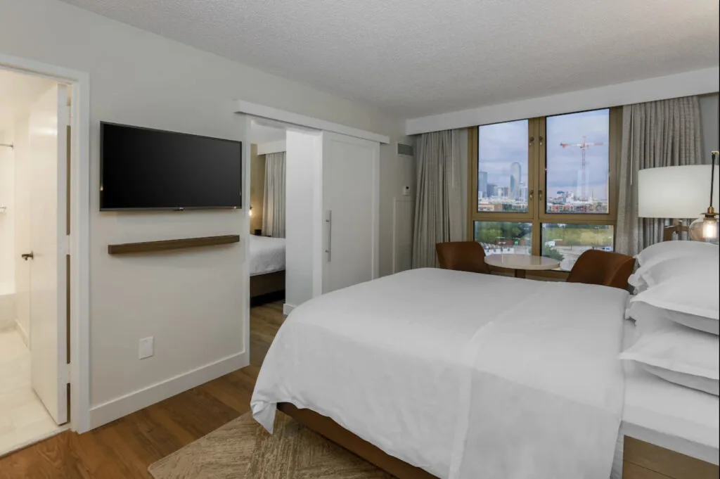 Sheraton Suites Market Center Dallas suite room with TV and view of Dallas 