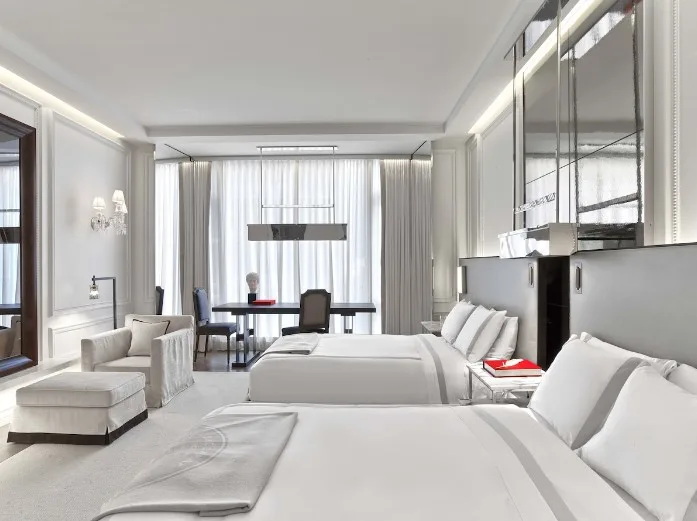 View of the bedroom of the Baccarat Hotel and Residences New York, a hotel in NYC with an indoor pool.