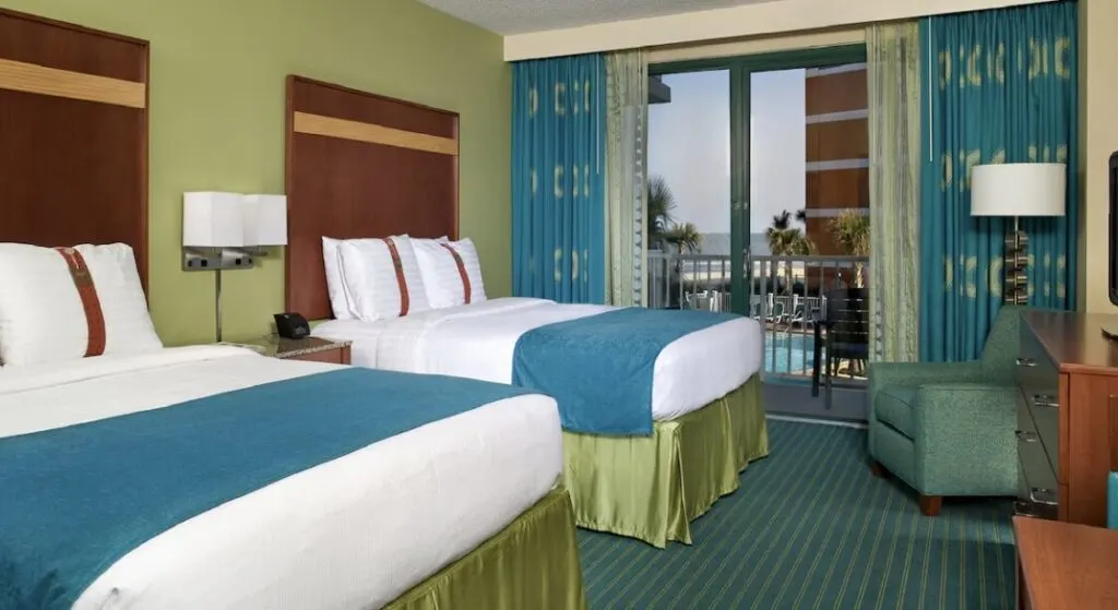 green and blue hotel room interior at Holiday Inn & Suites Virginia Beach - North Beach